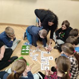 Grupa uczniów klasy 1 a, 1 c układająca puzzle- drogę dla ozobota. 