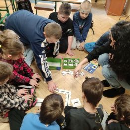 Grupa uczniów klasy 1 a, 1 c układająca puzzle- drogę dla ozobota. 