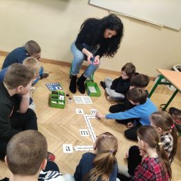 Grupa uczniów klasy 1 a, 1 c układająca puzzle- drogę dla ozobota. 