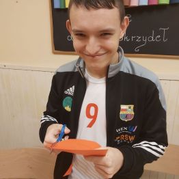 Chłopiec wycinanał z szablonu maskę.
