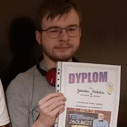 chłopiec prezentuje swój dyplom