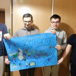 chłopcy prezentujący swój grupowy plakat