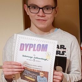 chłopiec prezentuje swój dyplom