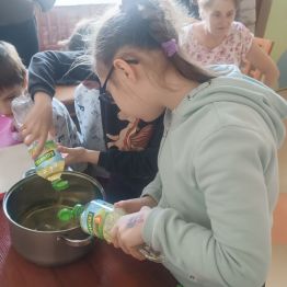 Wychowankowie wlewają olej do garnka.