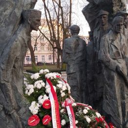 Wieńce biało -czerwone złożone pod pomnikiem.