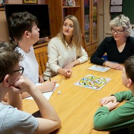 Pani Kasia  i Pani Edyta wieczorem grają wspólnie z wychowankami w grę planszową.