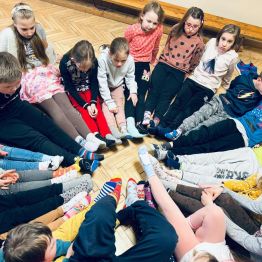 dzieci z klas I-III we wspólnym kręgu w kolorowych skarpetkach