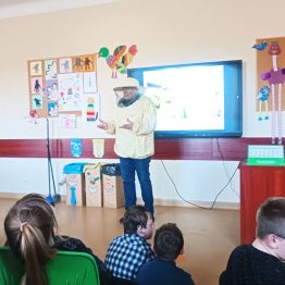 Pszczelarz w trakcie prowadzenia zajęć.