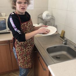 Hania stoi przy zlewie i myje talerz.