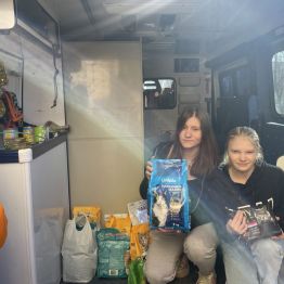 Uczniowie przekazują karmę pracownikowi schroniska