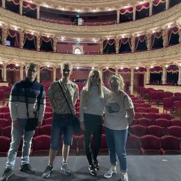 Uczniowie i wychowawczyni na teatralnej scenie.