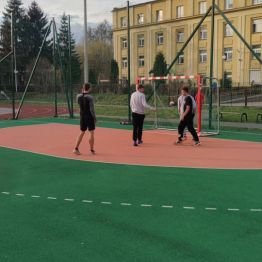 Chłopcy rozgrywają akcję na polu karnym podczas gry w piłkę nożną