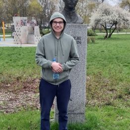 Wychowanek na tle posągu.