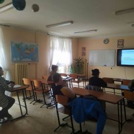 rodzice siedzą w ławkach, w tle tablica interaktywna