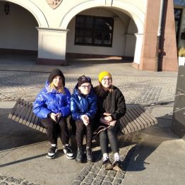 grupa dziewcząt siedzi na ławkach na Rynku