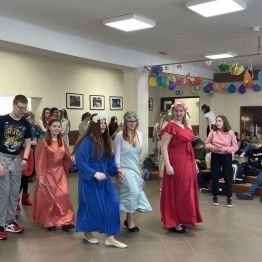 Uczennice w eleganckich sukniach podczas tańca.