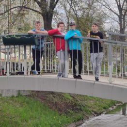 Czterech chłopców stoi na mostku.