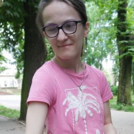 Pozowanie wychowanki na tle parku.