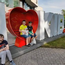 chłopcy siedzą pod napisem love kielce