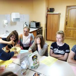 wychowawczyni pomaga w przygotowaniu maseczki