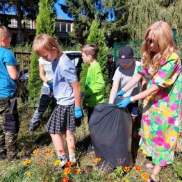 Uczniowie klas I-III wykonują prace porządkowe w ogródku szkolnym