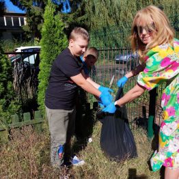 Uczniowie klas I-III wykonują prace porządkowe w ogródku szkolnym