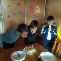 Bracia w dniu urodzin zdmuchują świeczki 