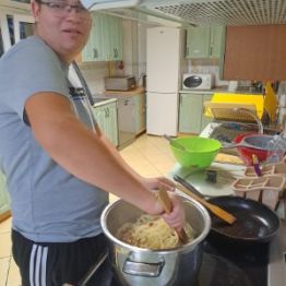 Wychowanek wyjmuje z garczka makaron.