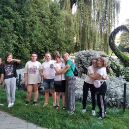 grupa wychowanek przed uformowanym z kwiatów łabędziem
