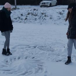 Dziewczynki na śniegu robią orła.