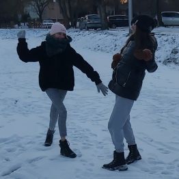 Dziewczynki rzucają się kulami śnieżnymi.