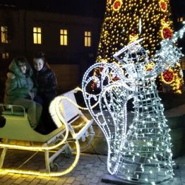 dziewczynki siedzą na świątecznych saniach