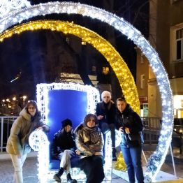 dziewczynki pozuja na tle iluminacji bombki świątecznej