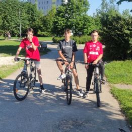Trzech chłopców stoi przy rowerach