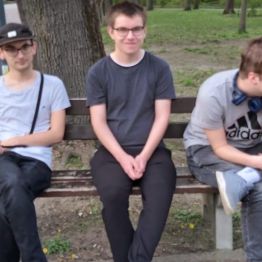 chłopcy siedzą na ławce w parku