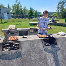 Nasz uczeń podczas grillowania kiełbasek