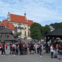 Grupa osób stojąca na Rynku w Kazimierzu Dolnym.