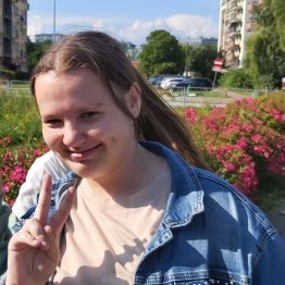 Zadowolona dziewczynka na tle kwiatów.