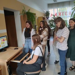 Pracownik biblioteki pokazuje uczniom na komputerze, jak korzysta się z katalogu internetowego oraz jak można sprawdzić czy książka jest dostępna.