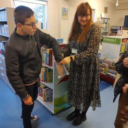 Wychowankowie losują zadanie do wykonania na zajęciach w bibliotece.