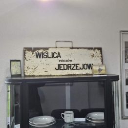 Tablica z napisem "Wiślica Pińczów Jędrzejów". Gablota z zastawą stołową