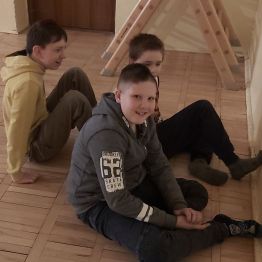 Chłopcy stopami dotykają ściany.