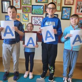 Dzieci w niebieskich strojach z literą A - solidarni dla autyzmu