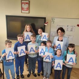 Dzieci w niebieskich strojach z literą A - solidarni dla autyzmu