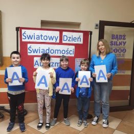 Dzieci w niebieskich strojach z literą A - solidarni dla autyzmu