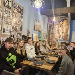 Wychowankowie wspólnie pozują do zdjęcia w pizzerii