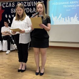Dwie absolwentki na środku sceny przemawiają do zebranych gości. 