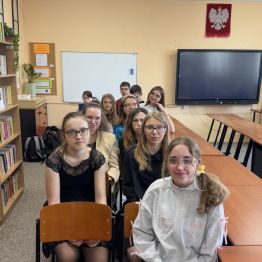 Uczestnicy konkursu siedzą na krzesełkach w bibliotece.