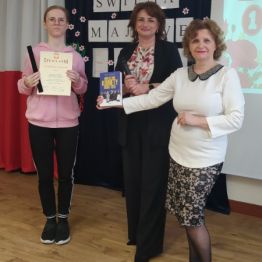 Dziewczynka odbiera nagrodę za udział w Konkursie 