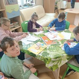 Grupa uczniów przygotowuje laurki dla rodziców.